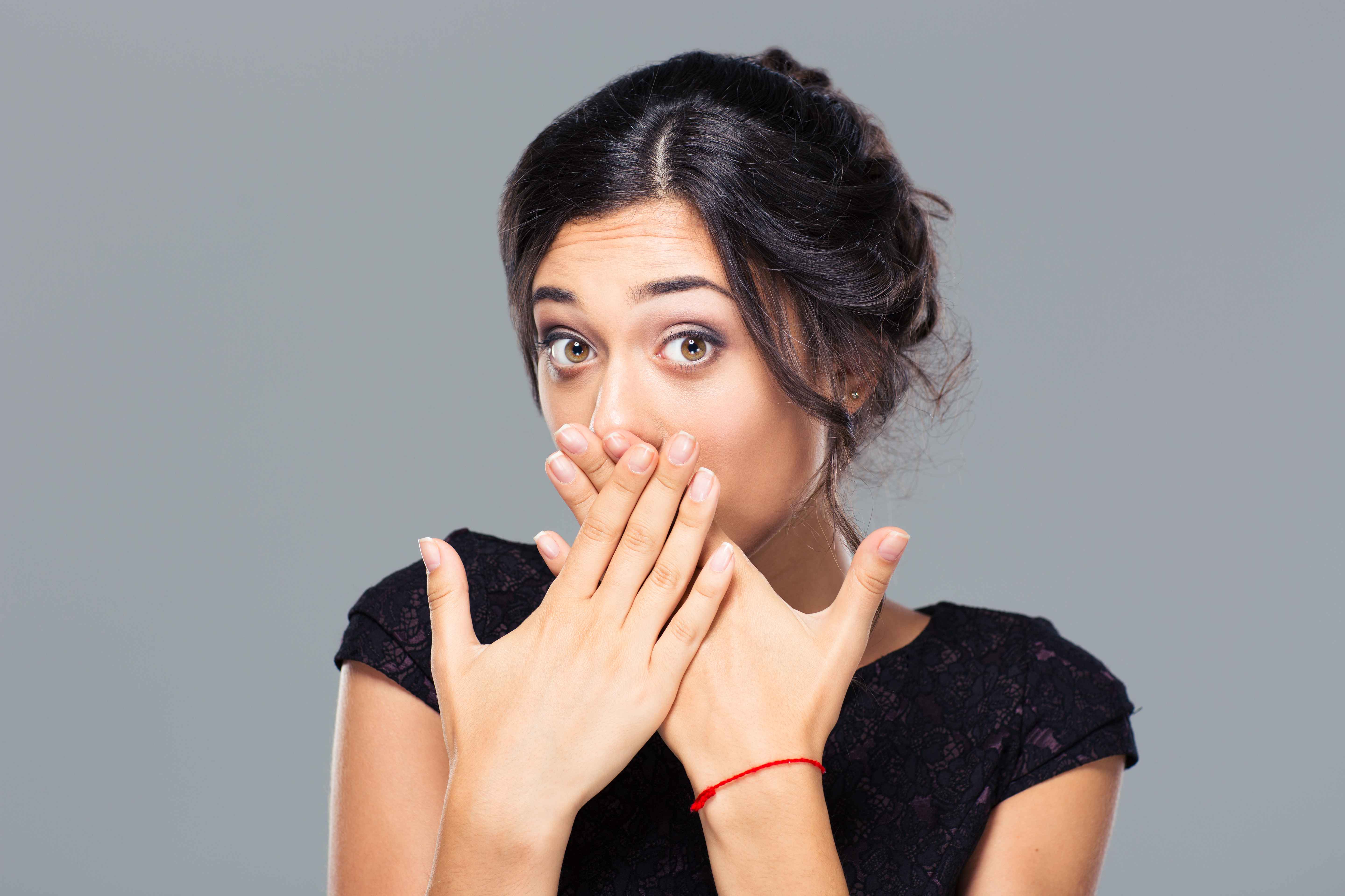 Portrait of a young woman covering her mouth